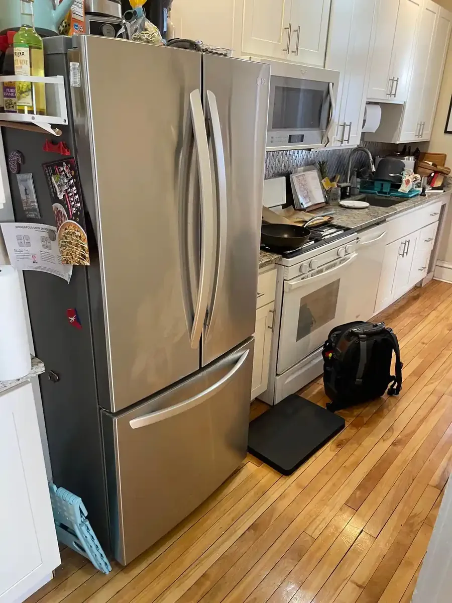 Appliance repair technician with LG French-door refrigerator and tool bag in Minneapolis